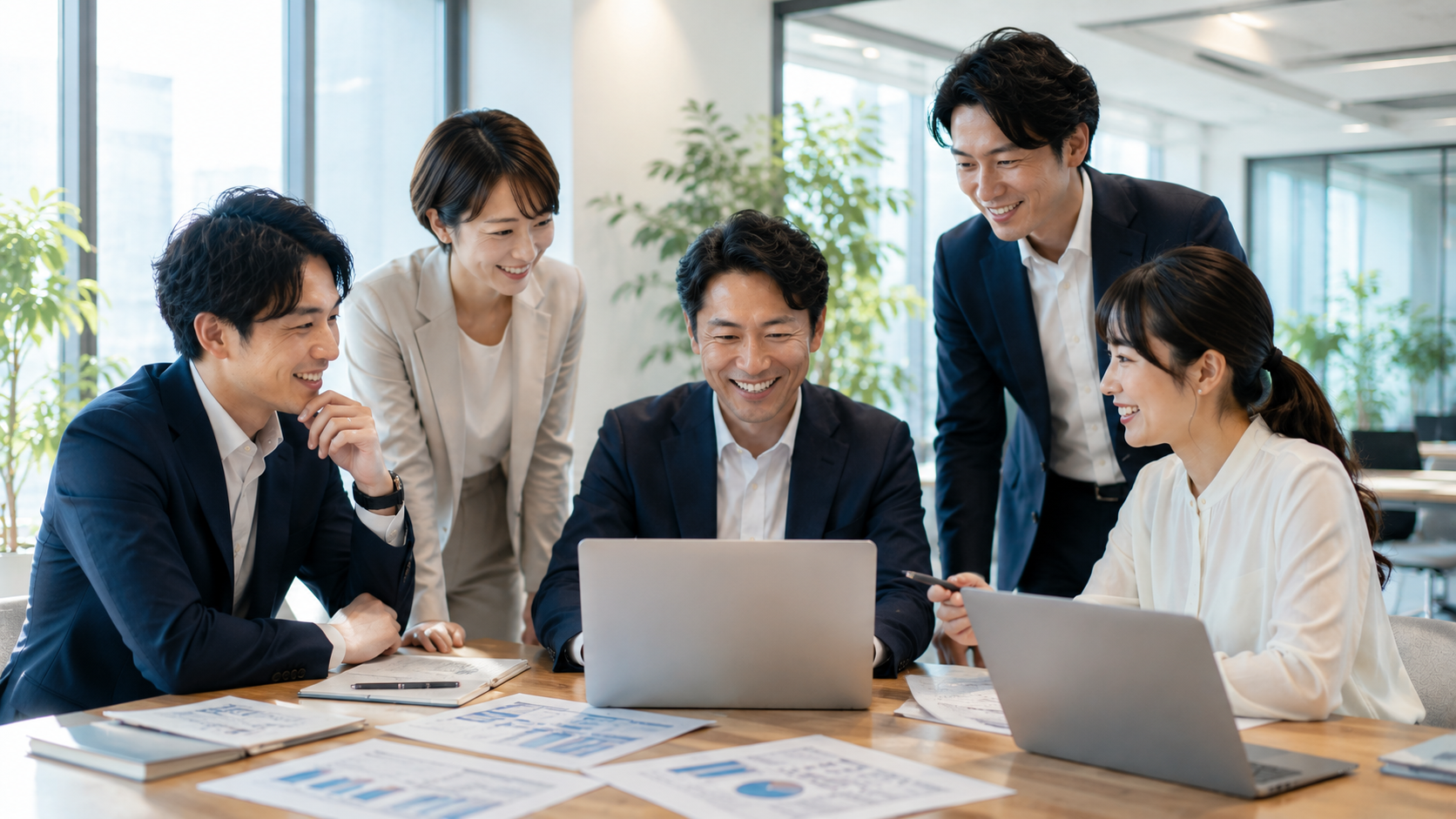 若い従業員が資料を囲んで事業改善について話し合う様子